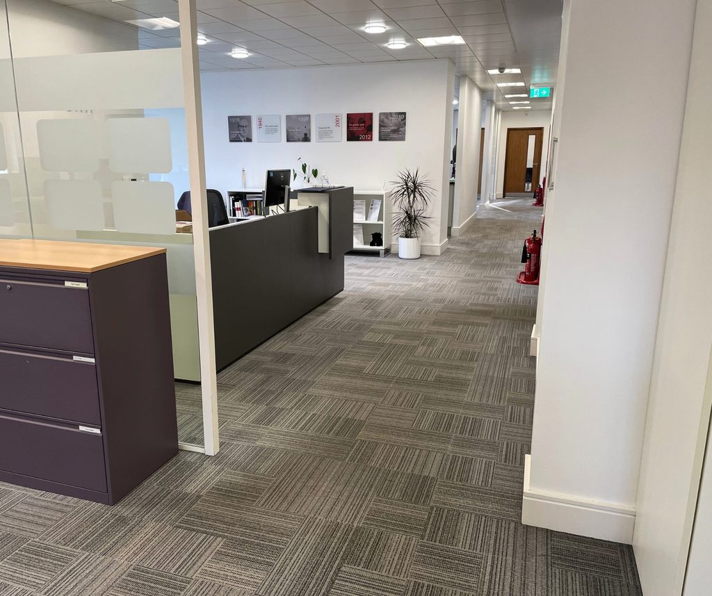 Communal area cleaning: tidy reception and carpeted corridor in a shared office building